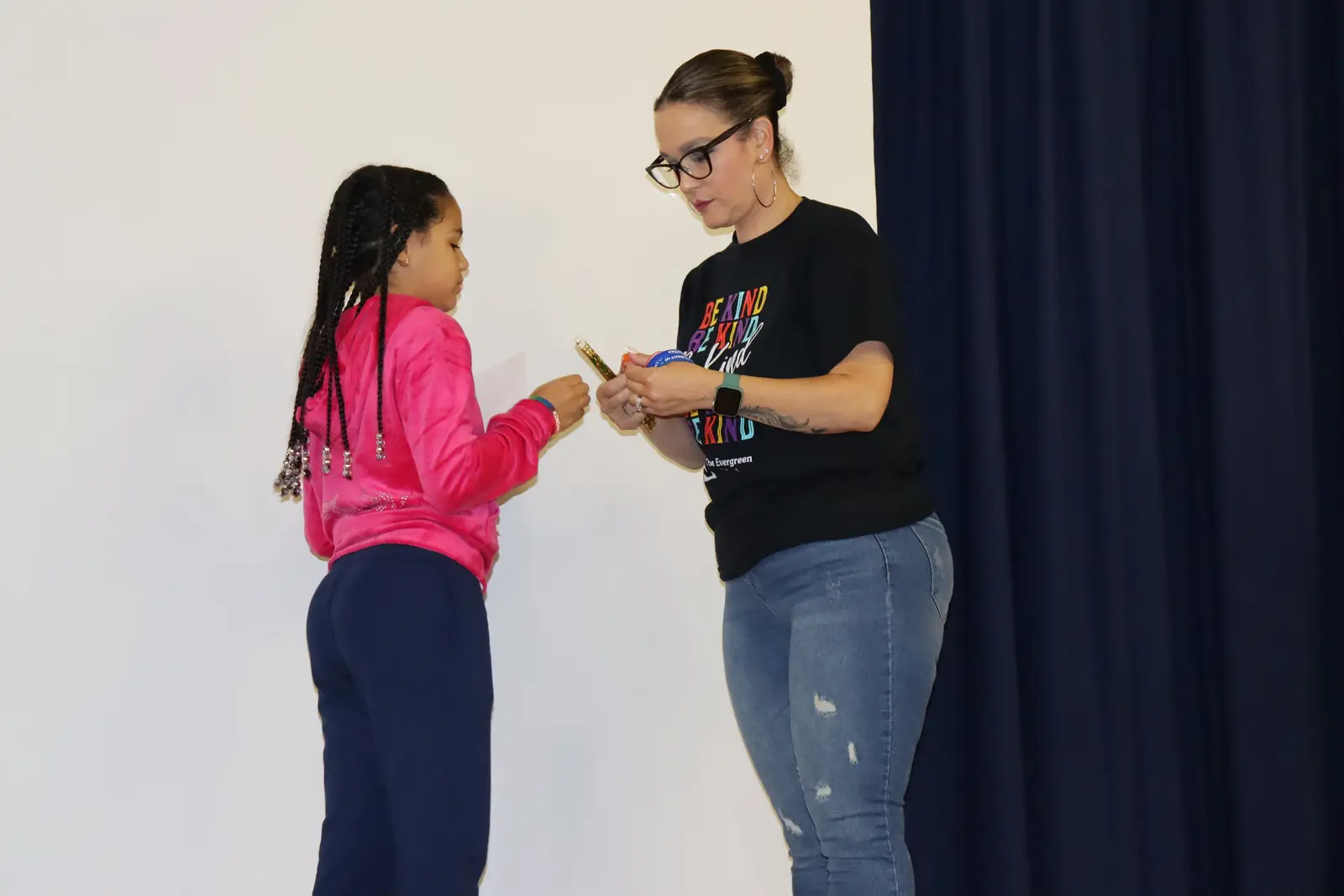 Teacher presenting award to student on stage