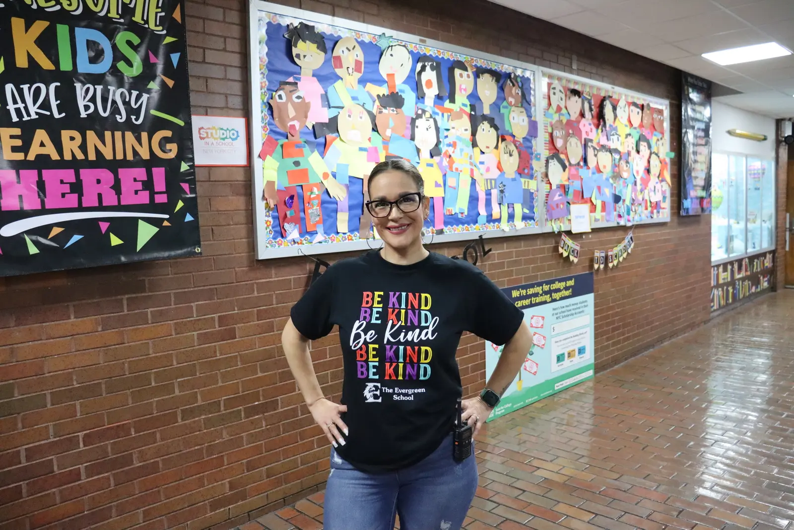 Teacher wearing Be Kind t-shirt in school hallway