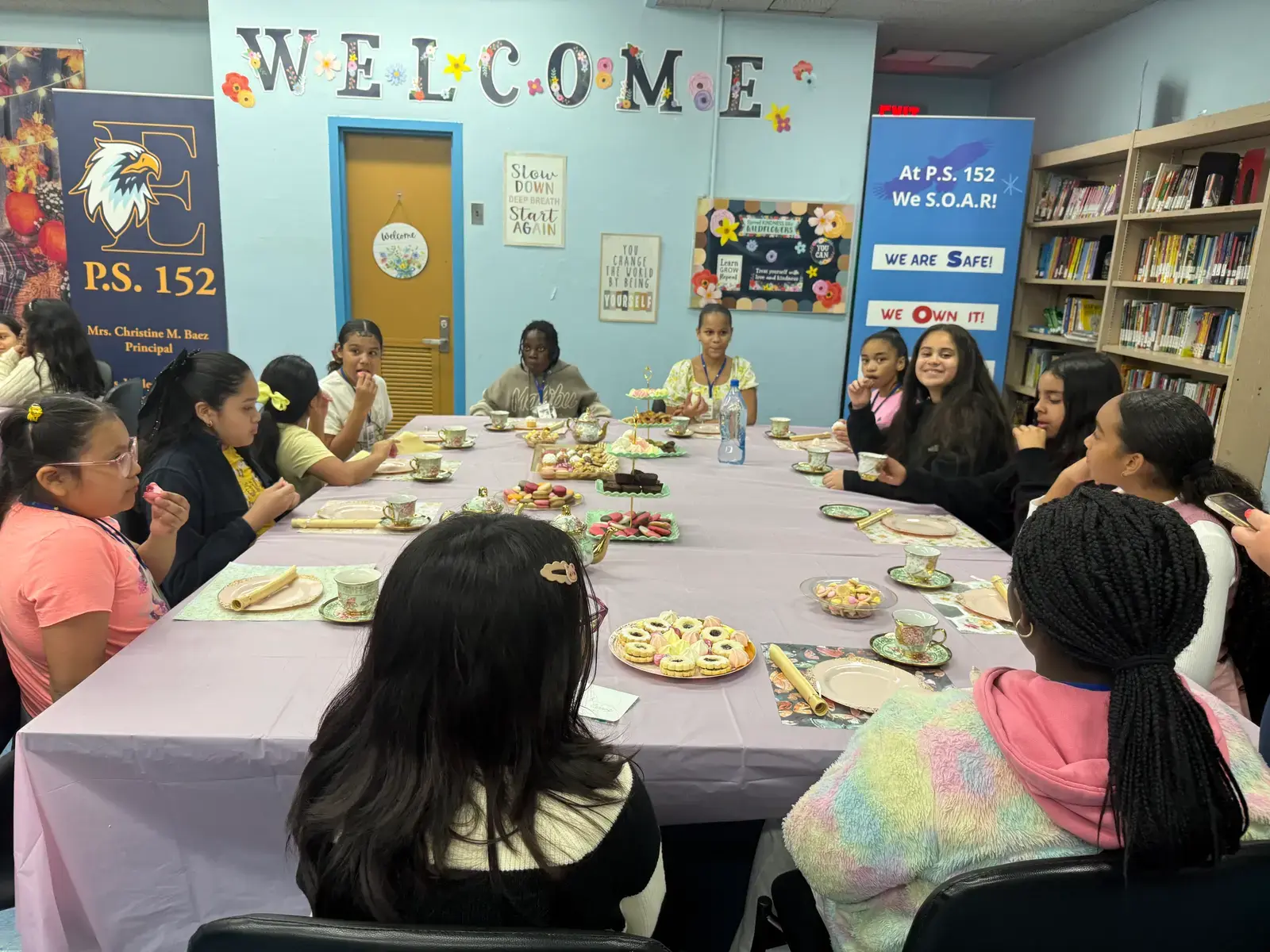 Students enjoying lunch together at decorated table in school library