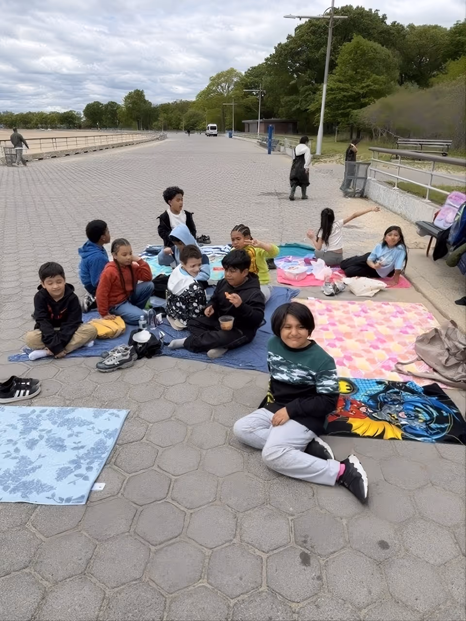 Students sitting on blankets during an outdoor field trip picnic
