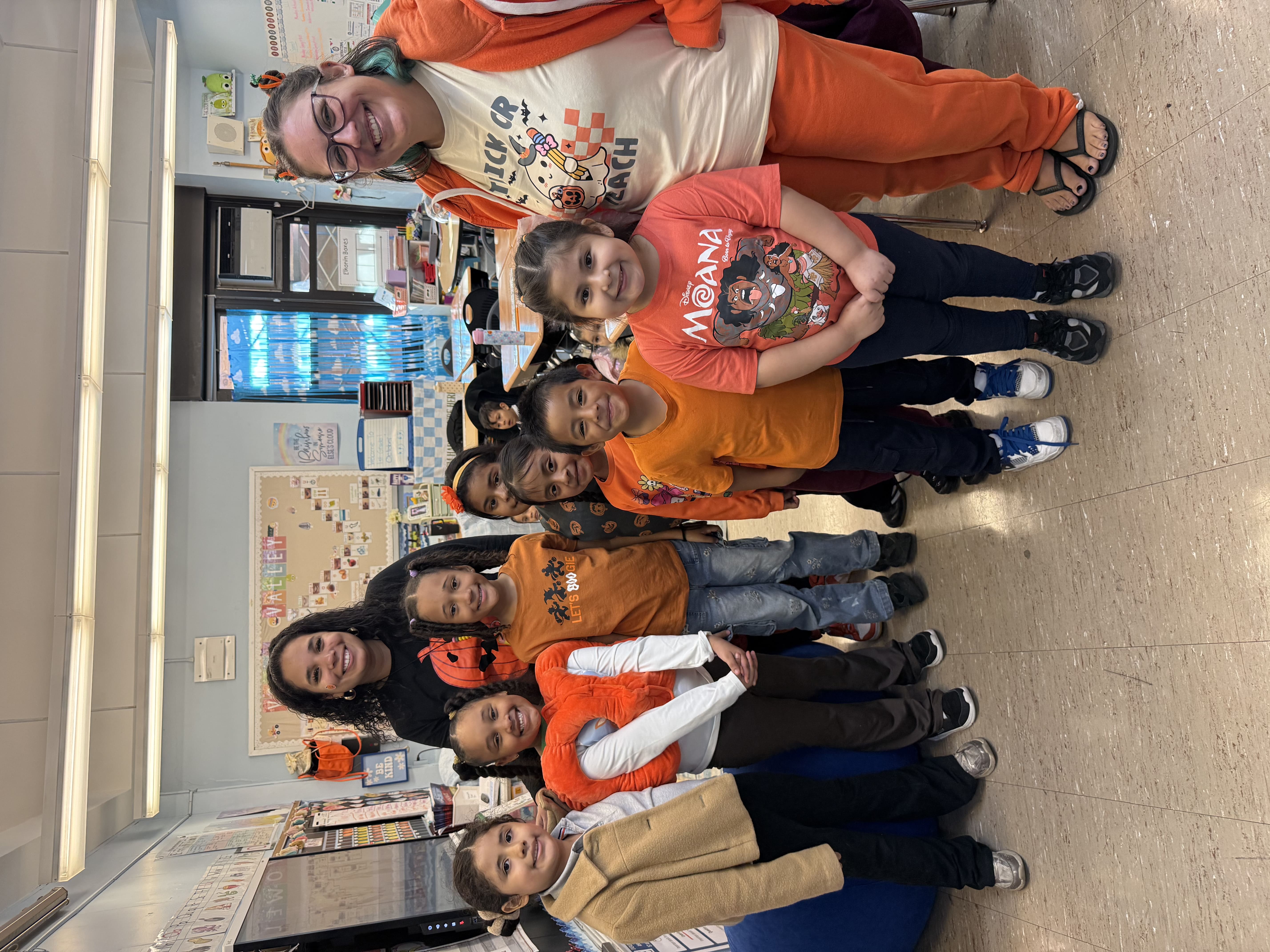 PS 152 teacher with a large group of students dressed in orange for Pumpkin Day