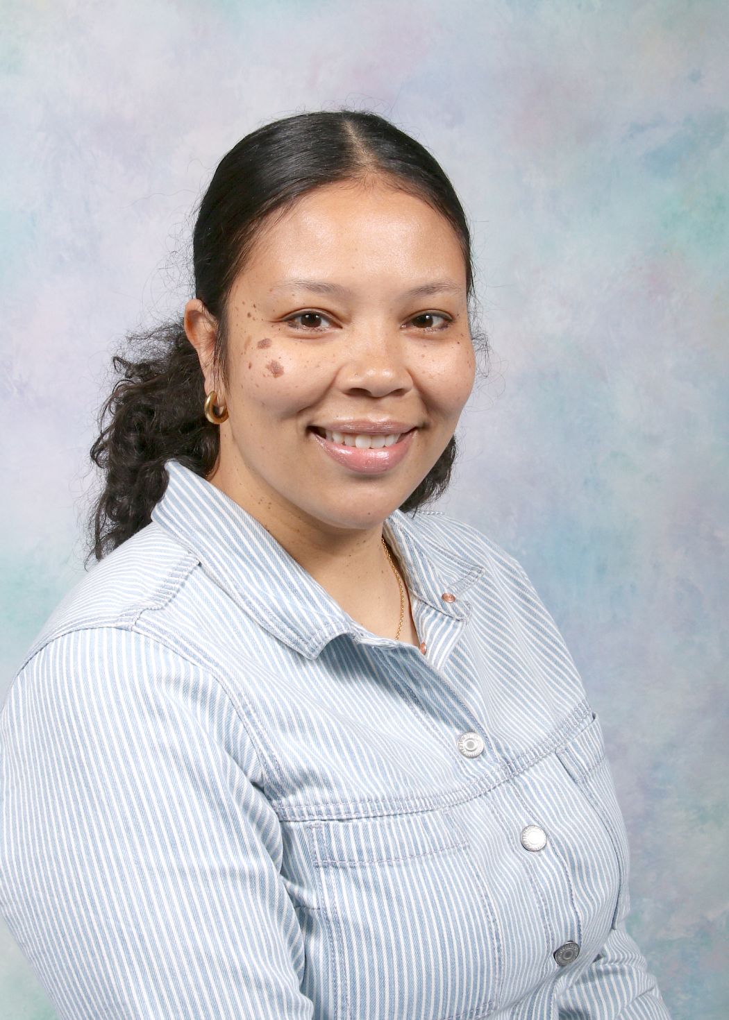 Ms. Gomera smiling in a professional staff portrait photo