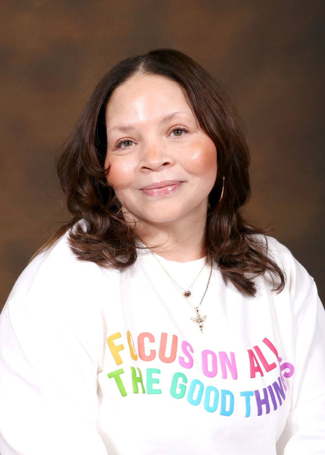 Ms. Suarez staff portrait photo smiling in colorful sweatshirt