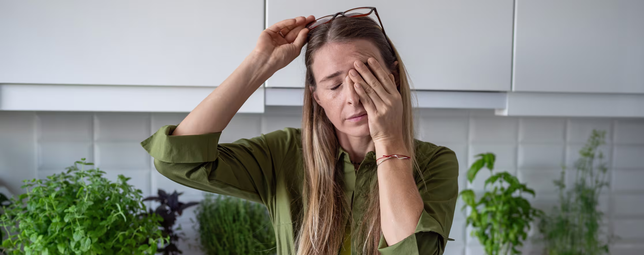 Exhausted woman rubbing her face, representing mood changes and anxiety linked to hormonal shifts during menopause.