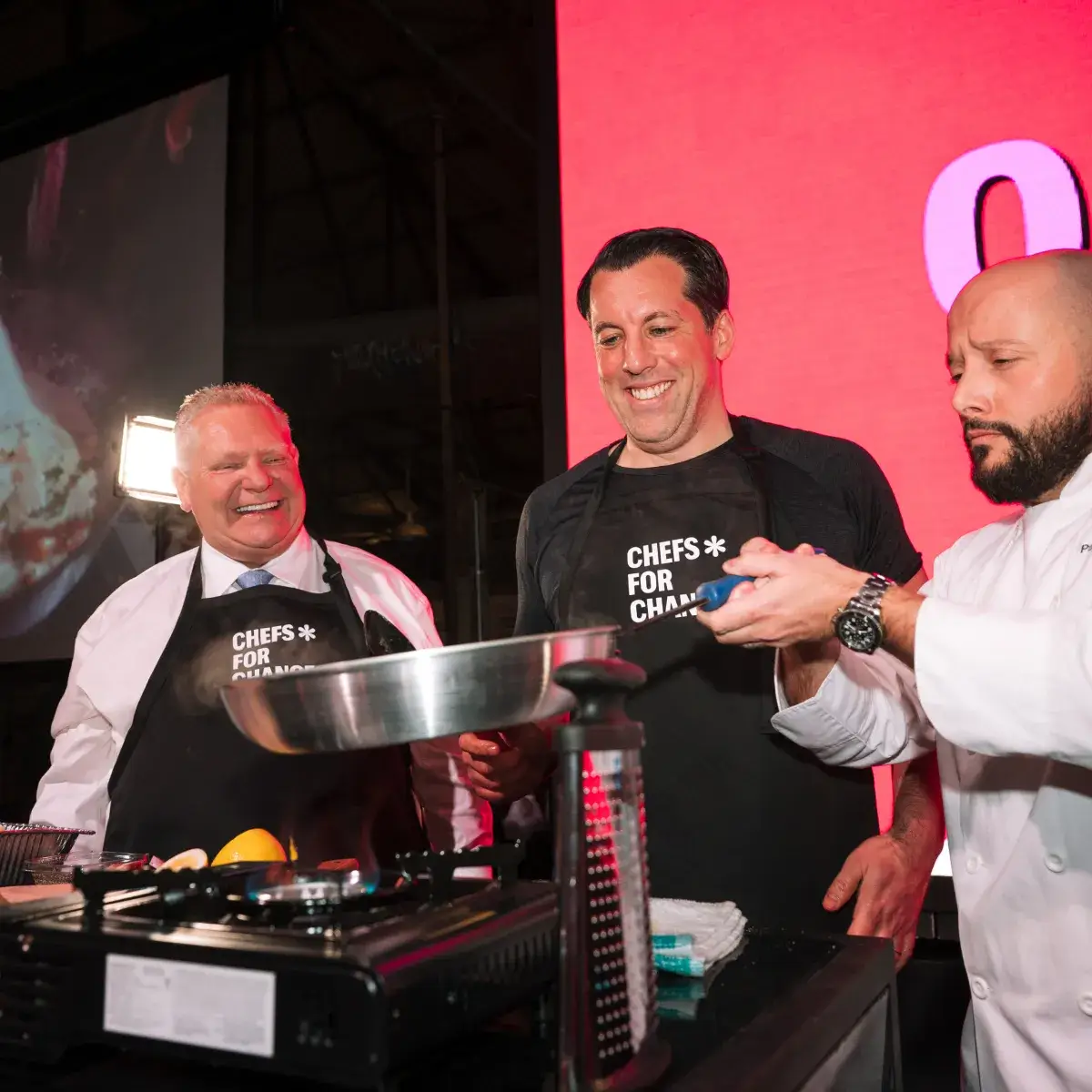 Doug Ford and two other men men standing in front of a frying pan.