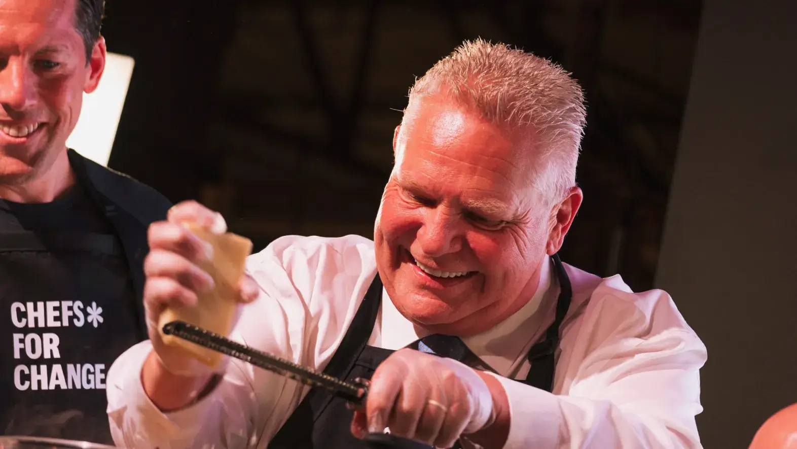 Doug Ford grating cheese during cook off show.