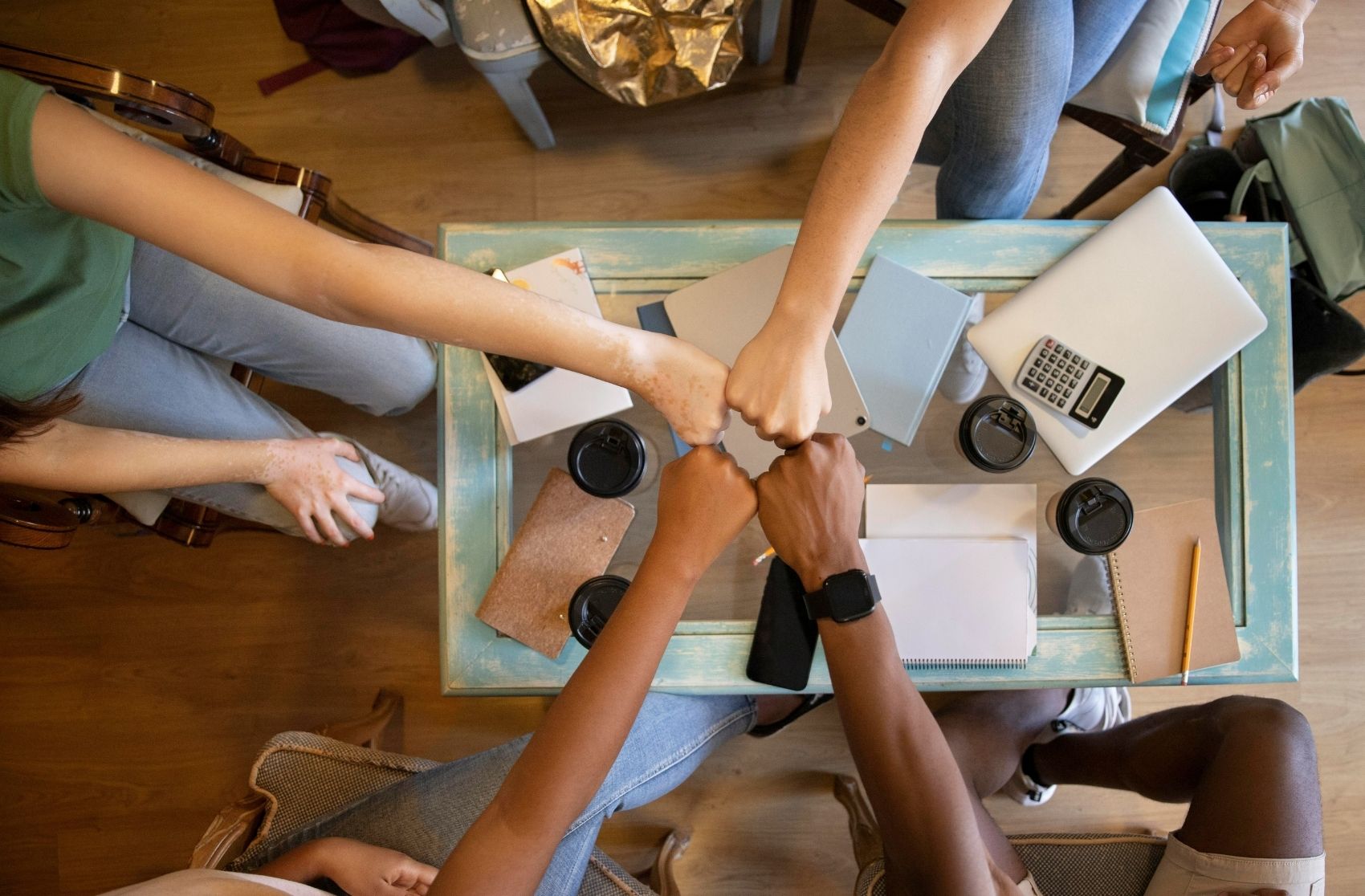 Group of People Holding Hands Over a Table