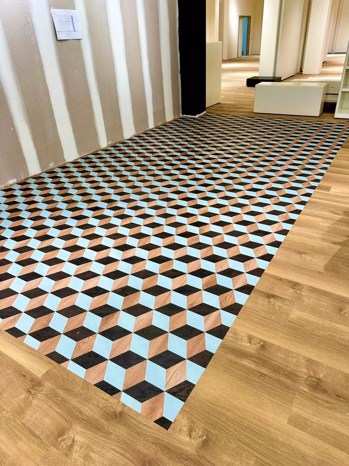 Vloerbekleding met houtlook naast een geometrisch tegelpatroon