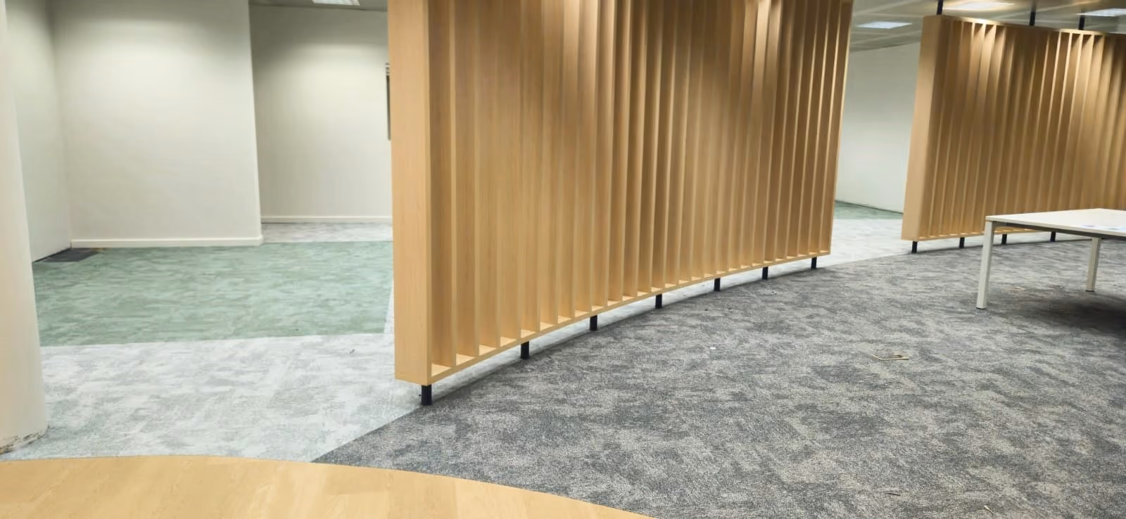 Tapijt en vloerbekleding rond een houten scheidingswand in een kantoor