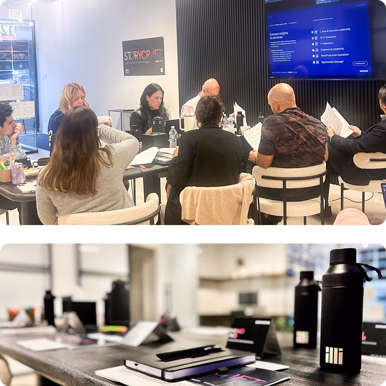 Group of people sitting around a conference table engaged in a meeting with a large screen displaying corporate leadership roles; table set with notebooks, water bottles, and documents.