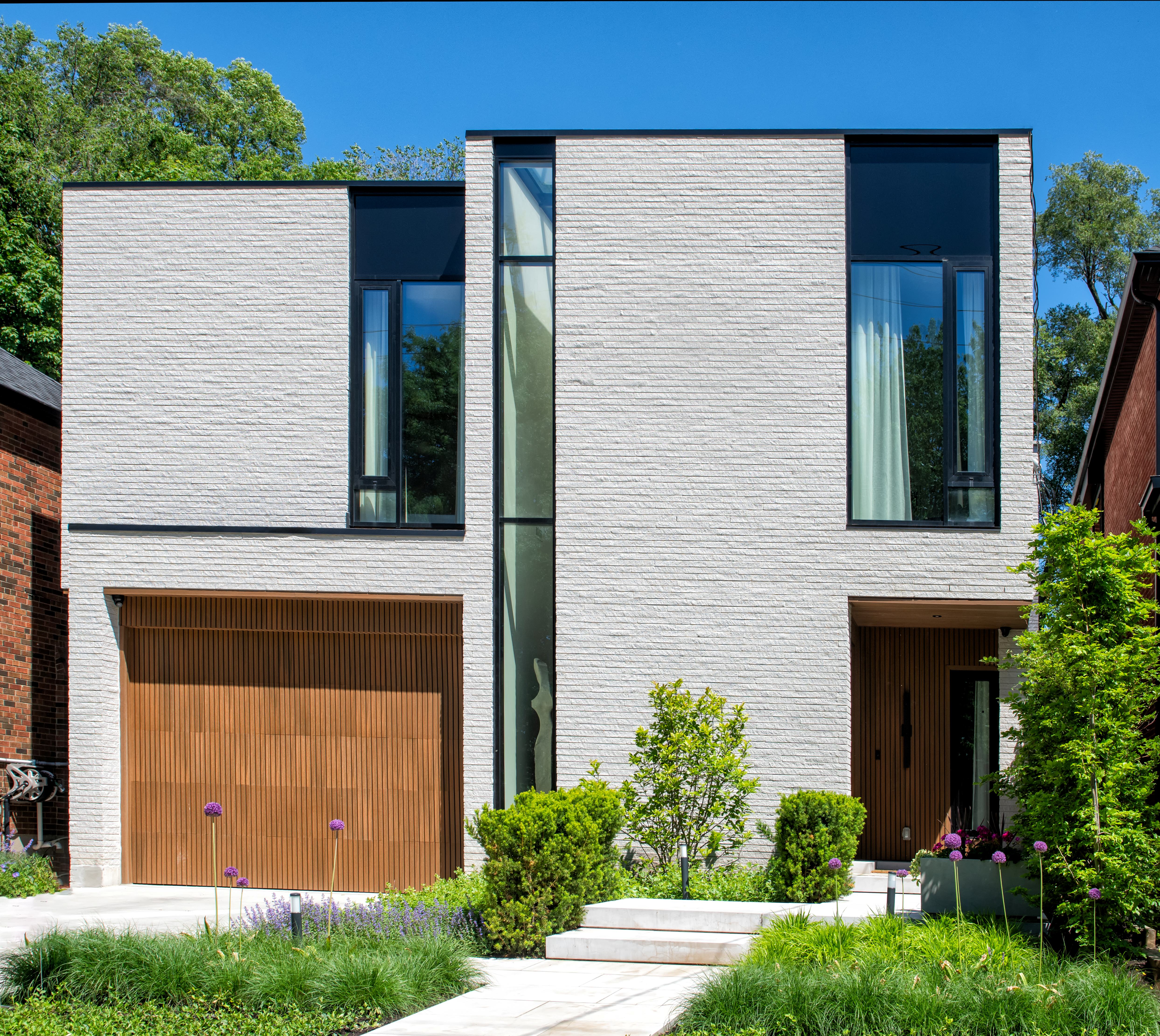 Contemporary white-brick custom home with cantilevered massing