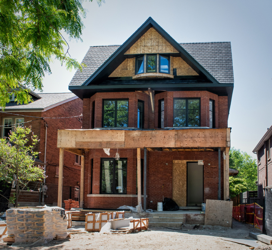 Brick residence under construction with exposed structural framing