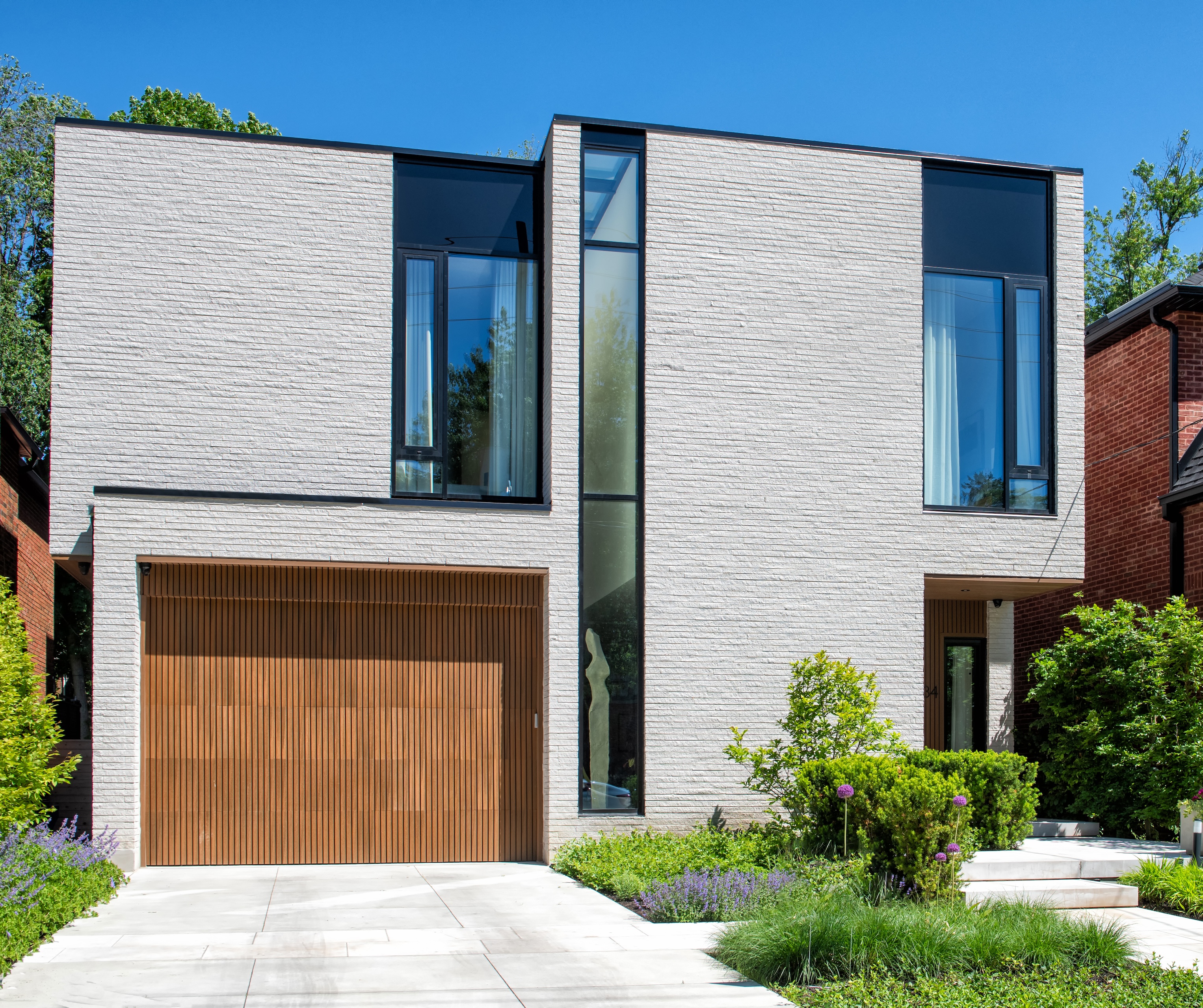Contemporary white-brick custom home with cantilevered massing