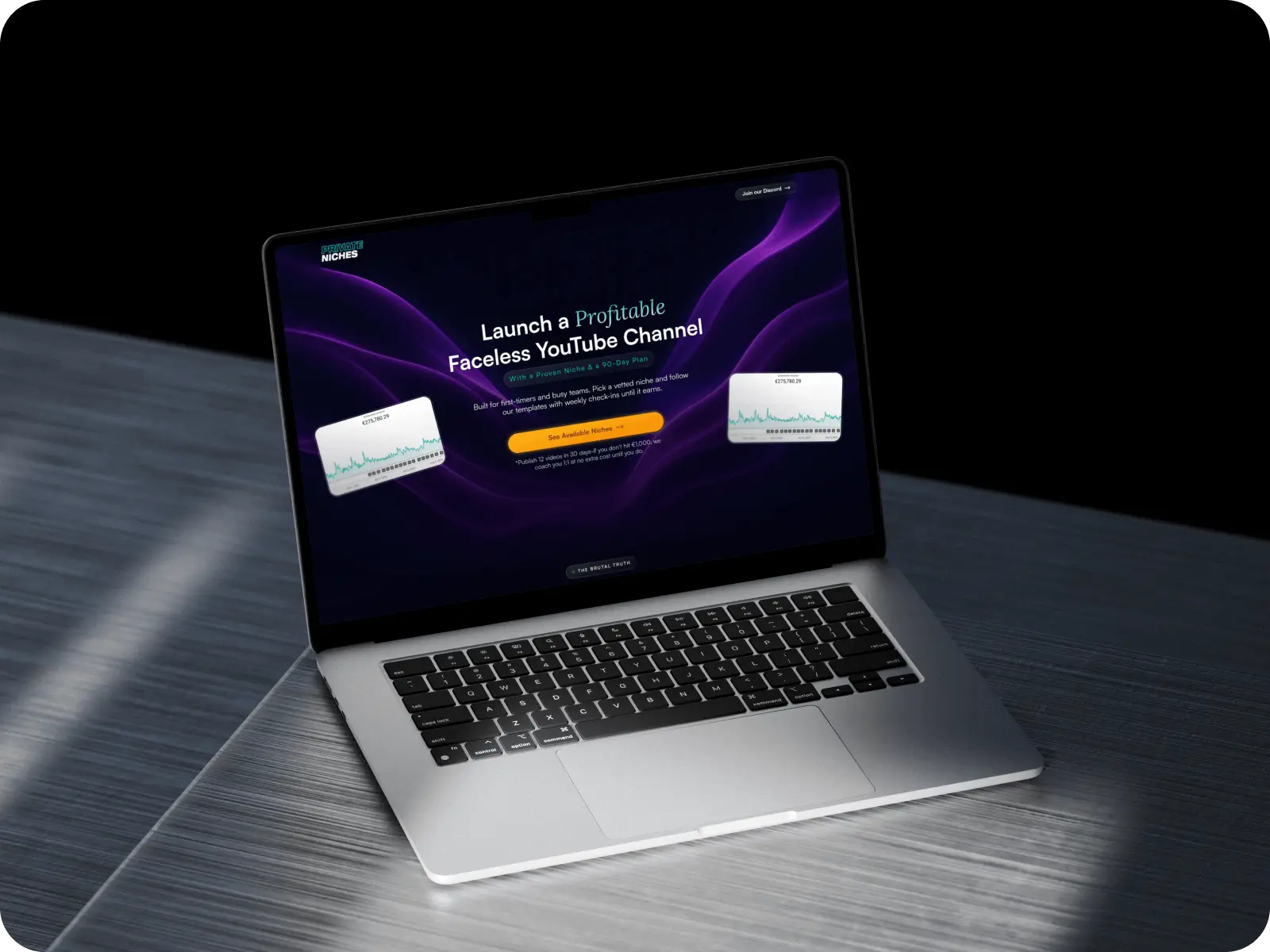 Laptop on a gray wooden surface displaying a website to launch a profitable faceless YouTube channel with graphs and a call-to-action button.