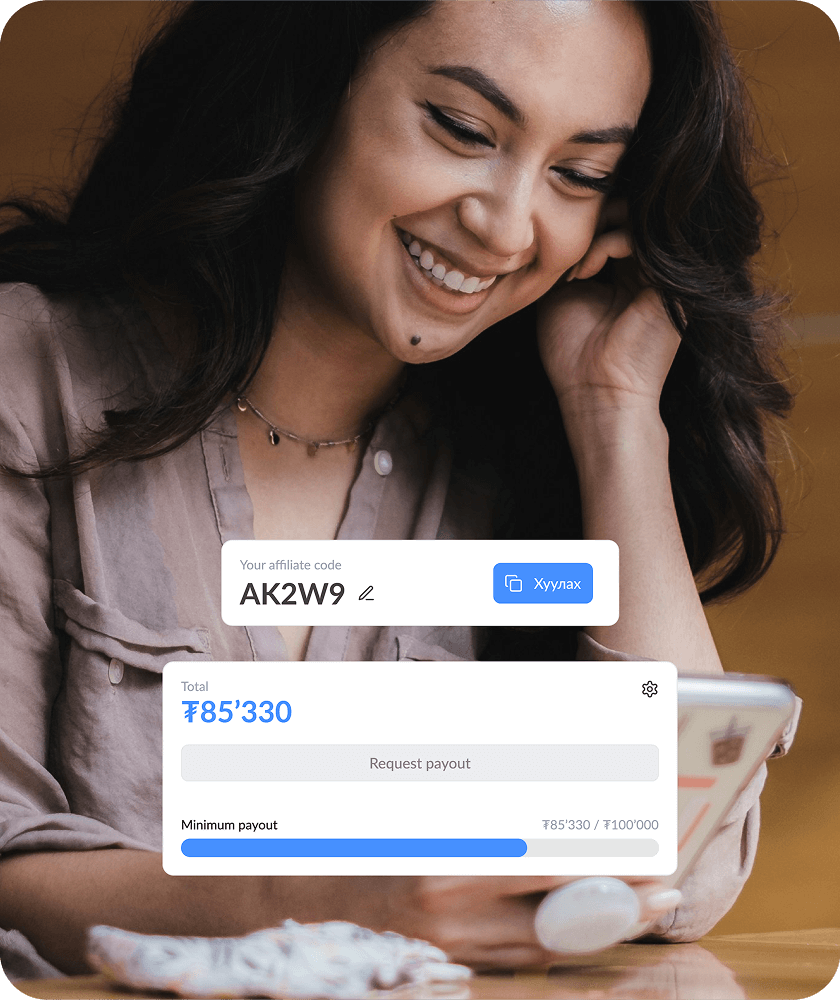 Smiling woman looking at her smartphone with an overlay showing affiliate code AK2W9 and payout progress bar near 85,330 currency units out of 100,000.