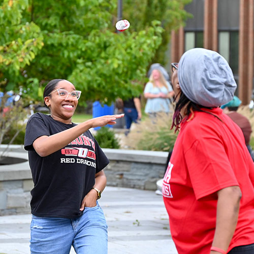 Students standing in a circle, smiling during Flop Ball exercise.