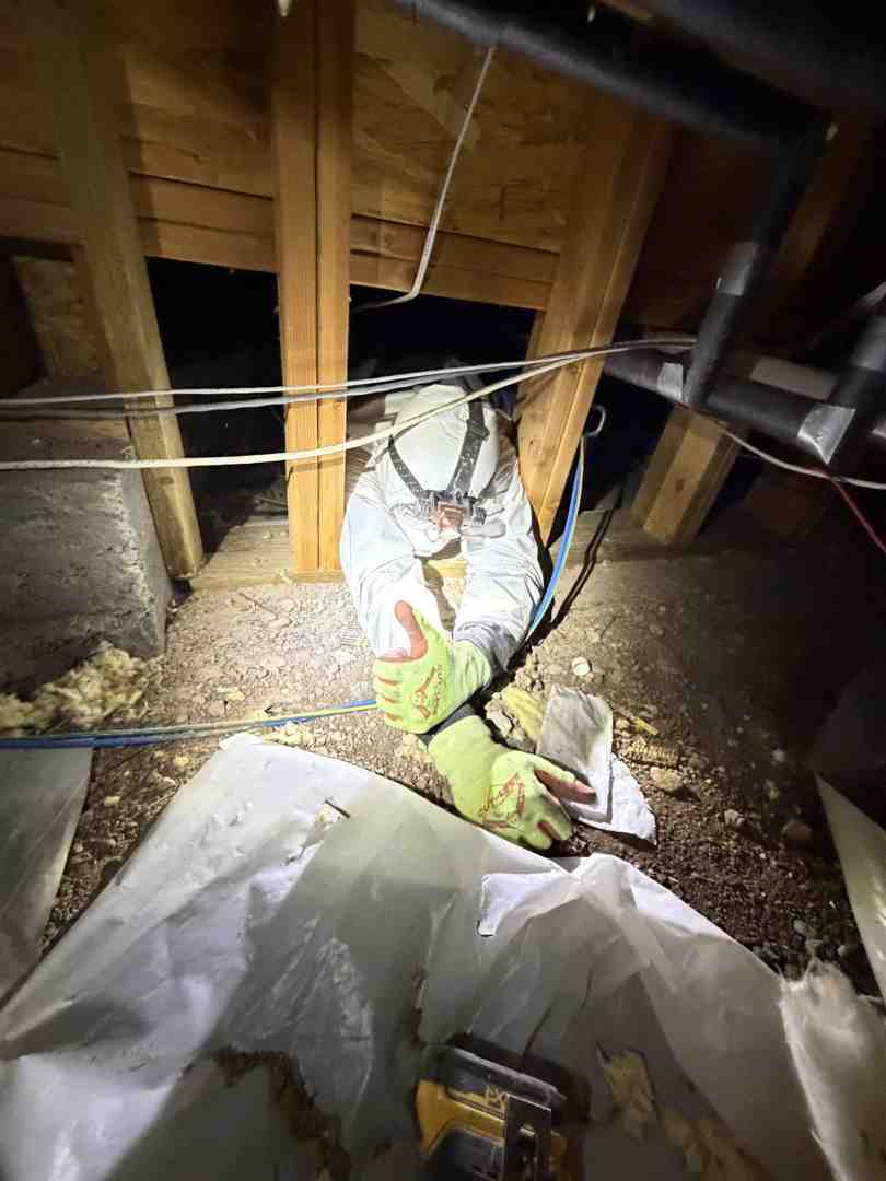 technician installing fiberglass insulation in a spacious home attic