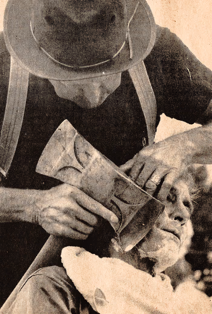 Historic photograph of lumberjack using an axe to shave a man's beard.