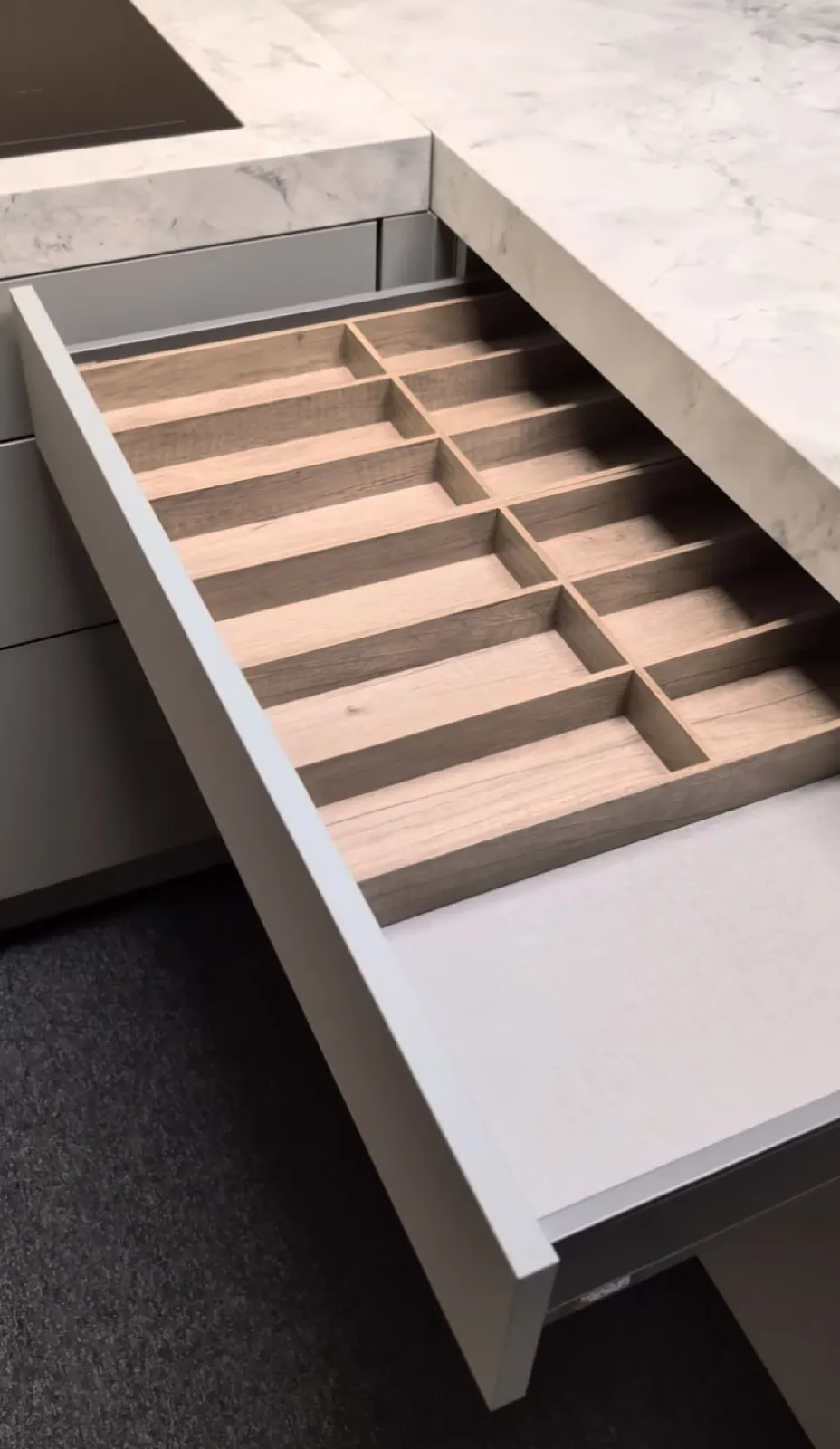 Ausgezogene Lade mit Besteckeinsatz aus Holz