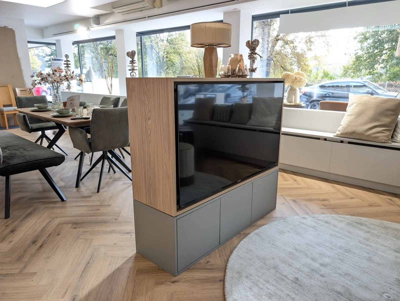 Freistehender TV-Schrank in Eiche auf grauem Sockel im Wohnraum