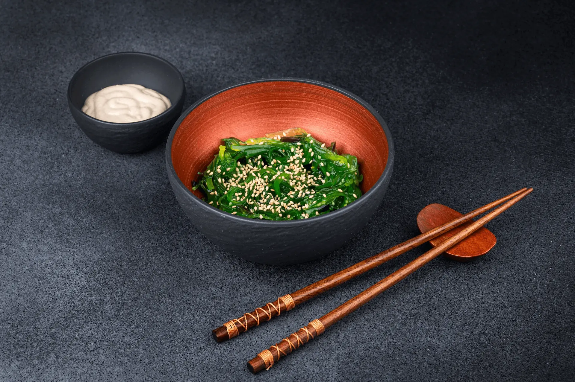 Rollos de sushi japonés servidos en un plato negro en un restaurante
