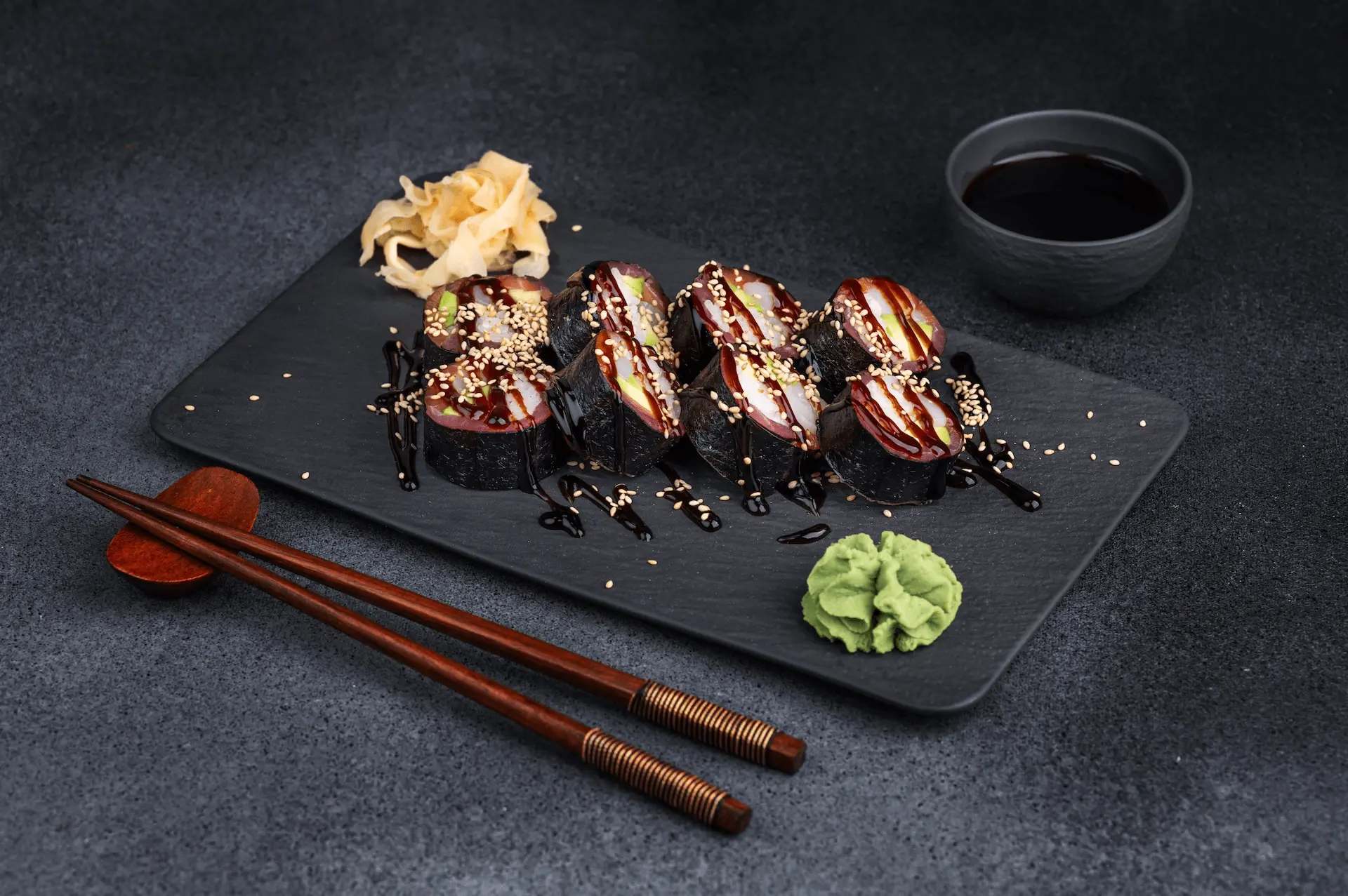 Platos japoneses servidos en platos negros sobre una mesa de restaurante