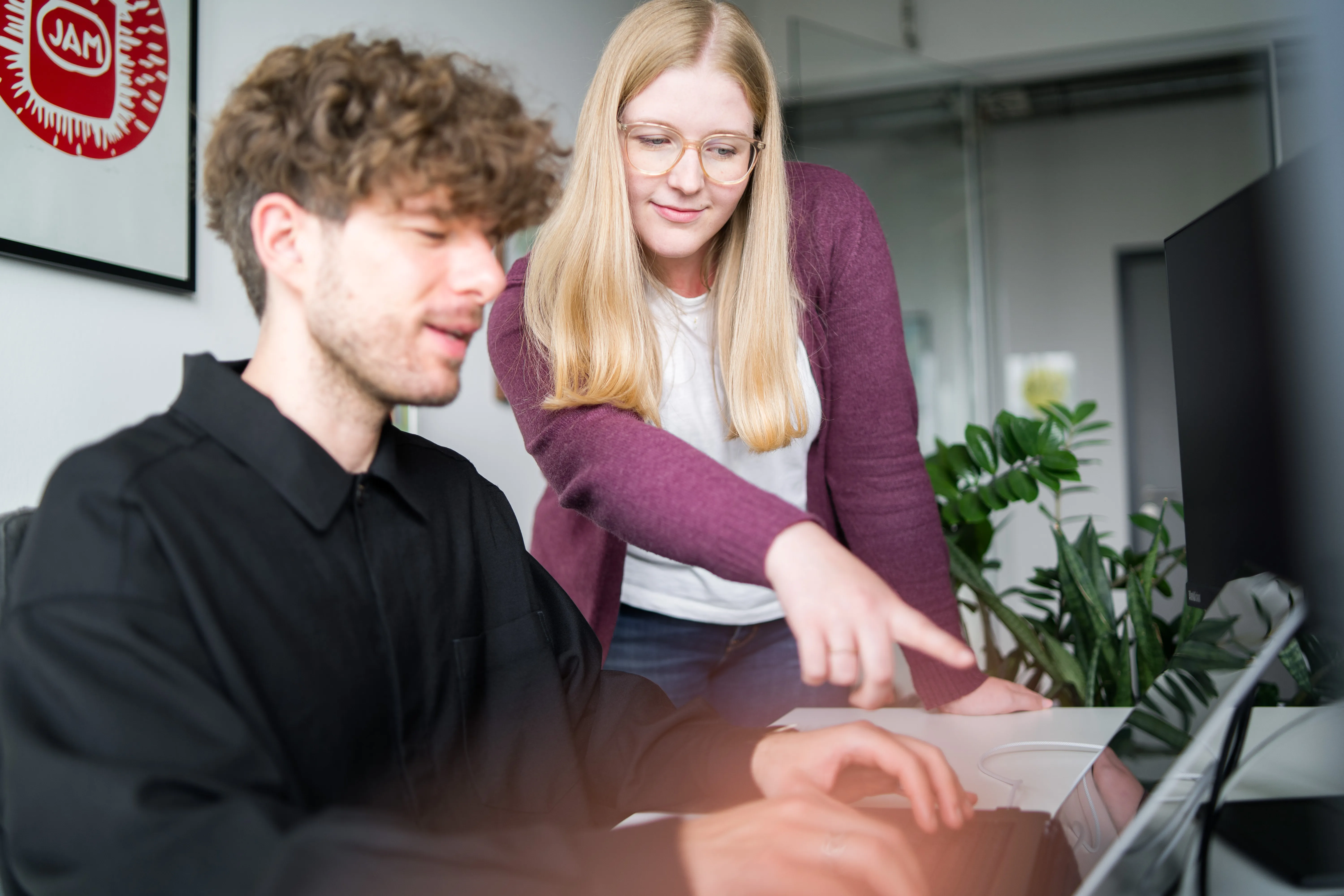 Kollegen unterstützen sich gegenseitig am Computer.