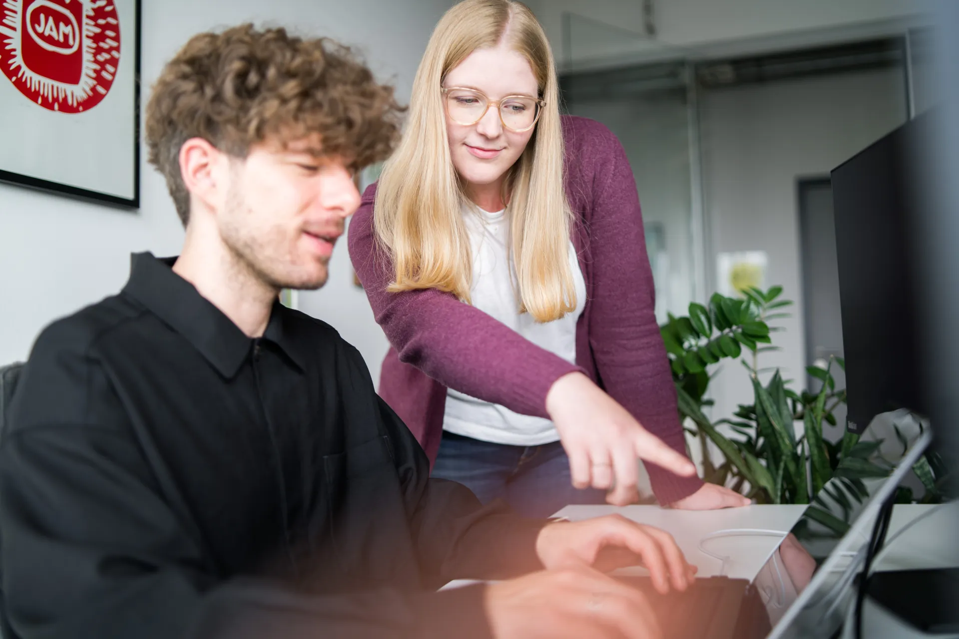 Kollegen unterstützen sich gegenseitig am Computer.