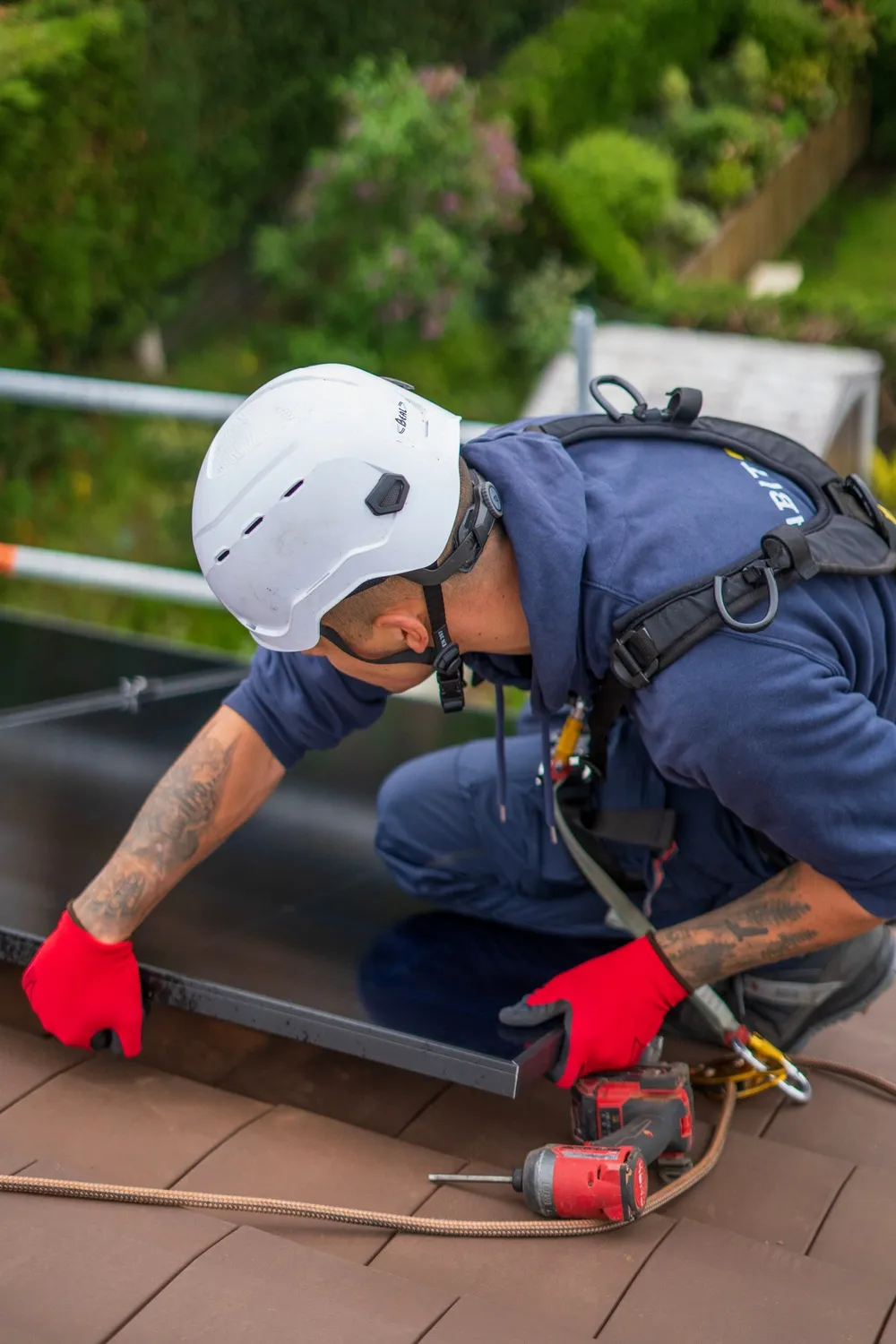 Installateur fixant des panneaux solaires sur un toit