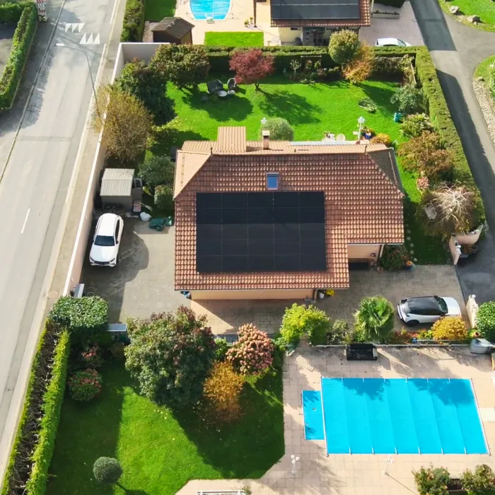 Toit d’une maison recouvert de panneaux solaires vu du ciel.