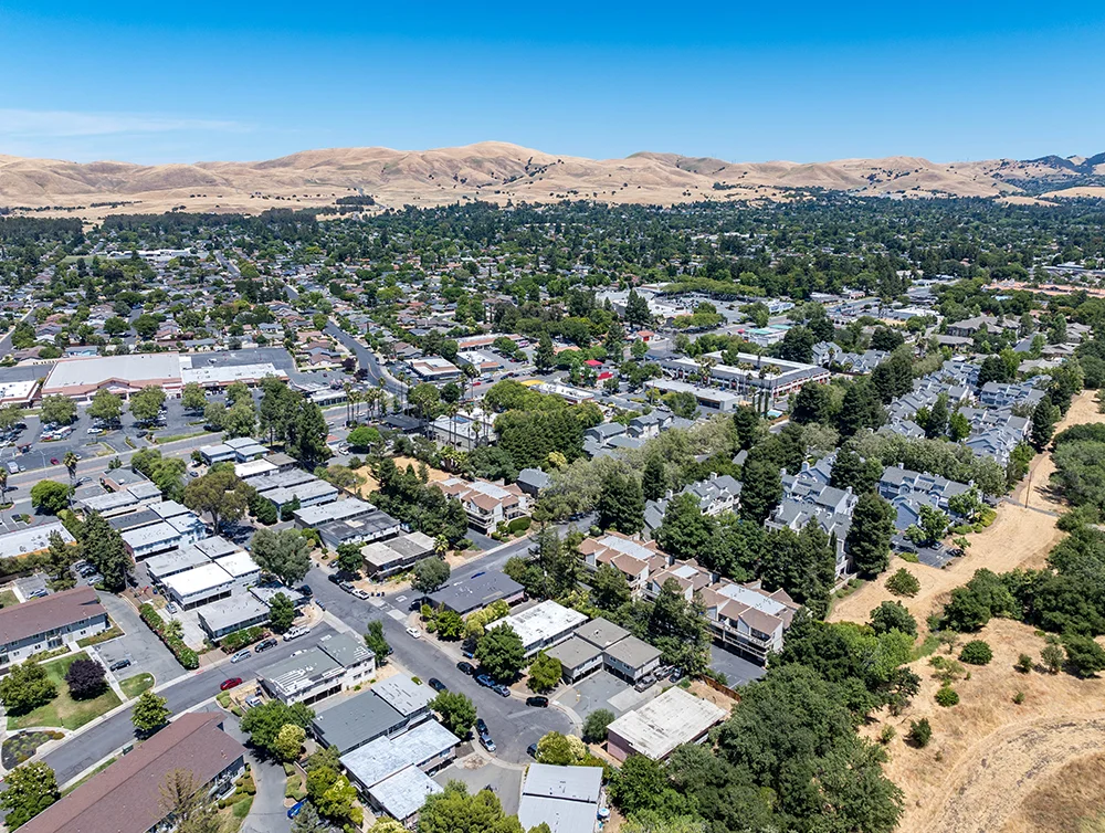 Drone images over a small community in Concord, California with dead hills and apartment buildings