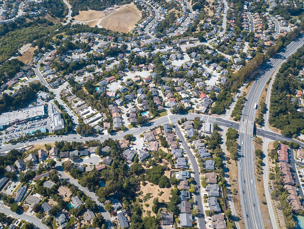 Aerial view of a San Mateo suburb houses development with highway traffic