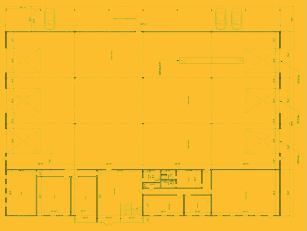 First-floor plan of a truck service facility showing large service bays, office core, restrooms, and stair.