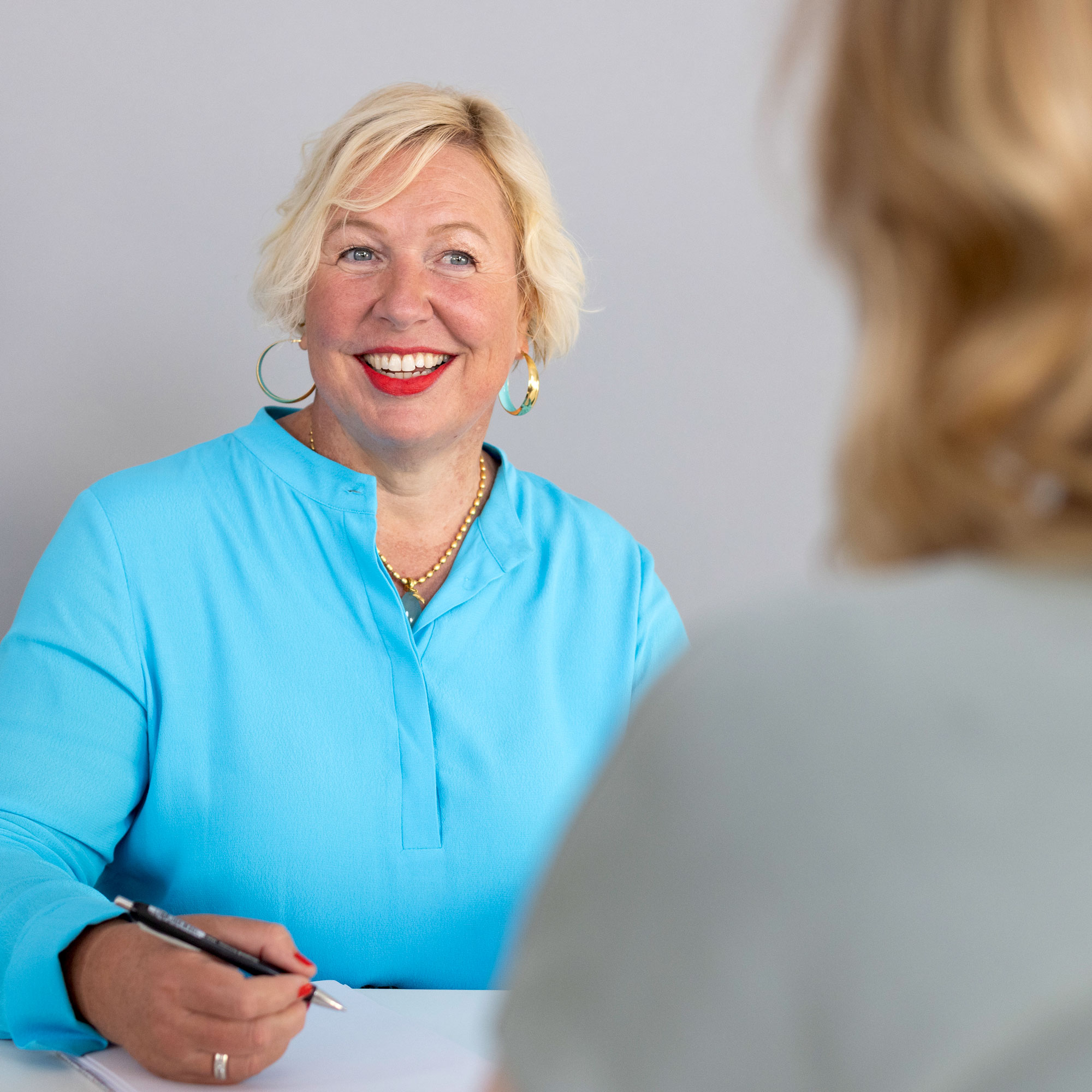 Blonde Frau im Gespräch mit Mentee