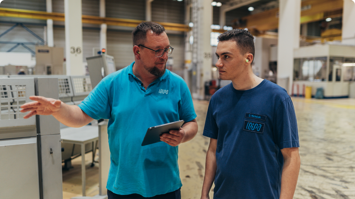 Auszubildender im LEIPA-Shirt sitzt an einem Tisch und nutzt simpleclub auf einem Tablet für seine Ausbildung.