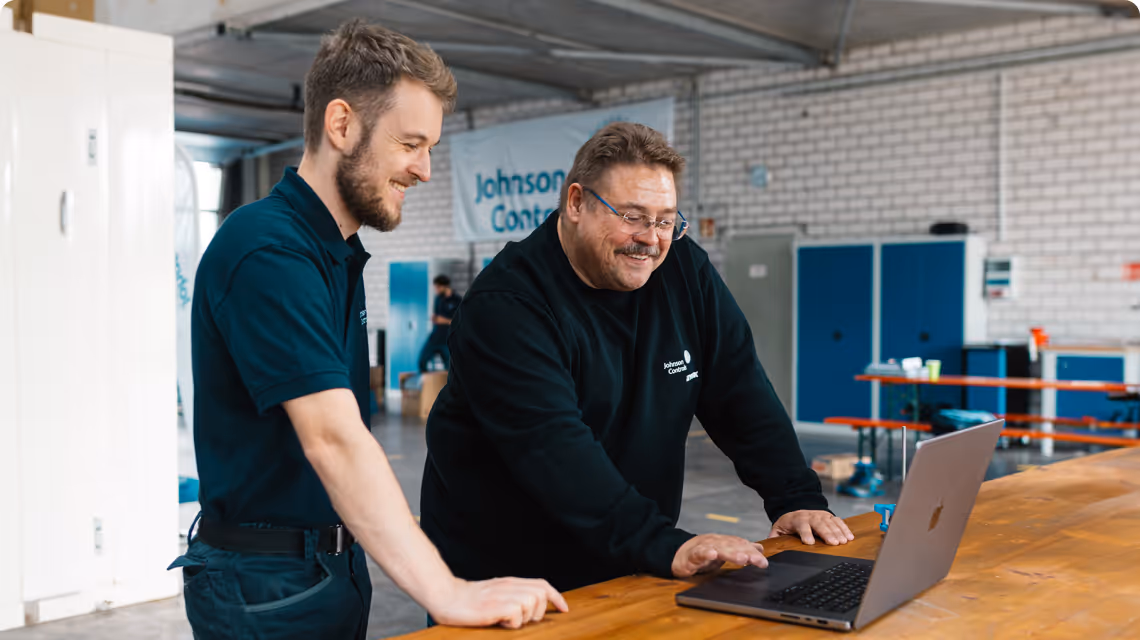 Zwei Auszubildende arbeiten gemeinsam an einer technischen Anlage und nutzen simpleclub zur Unterstützung ihrer Ausbildung.