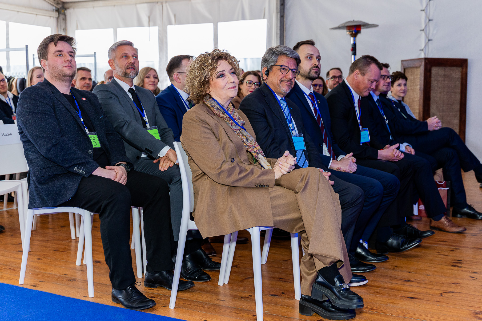 Grupa pięciu mężczyzn w garniturach trzymająca pamiątkowe szpachle, uśmiechnięta do zdjęcia