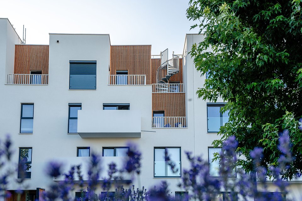 Mariusz Cegielski, Dyrektor Zarządzający Trei Real Estate Poland, rozmawia z kobietą w eleganckim wnętrzu.