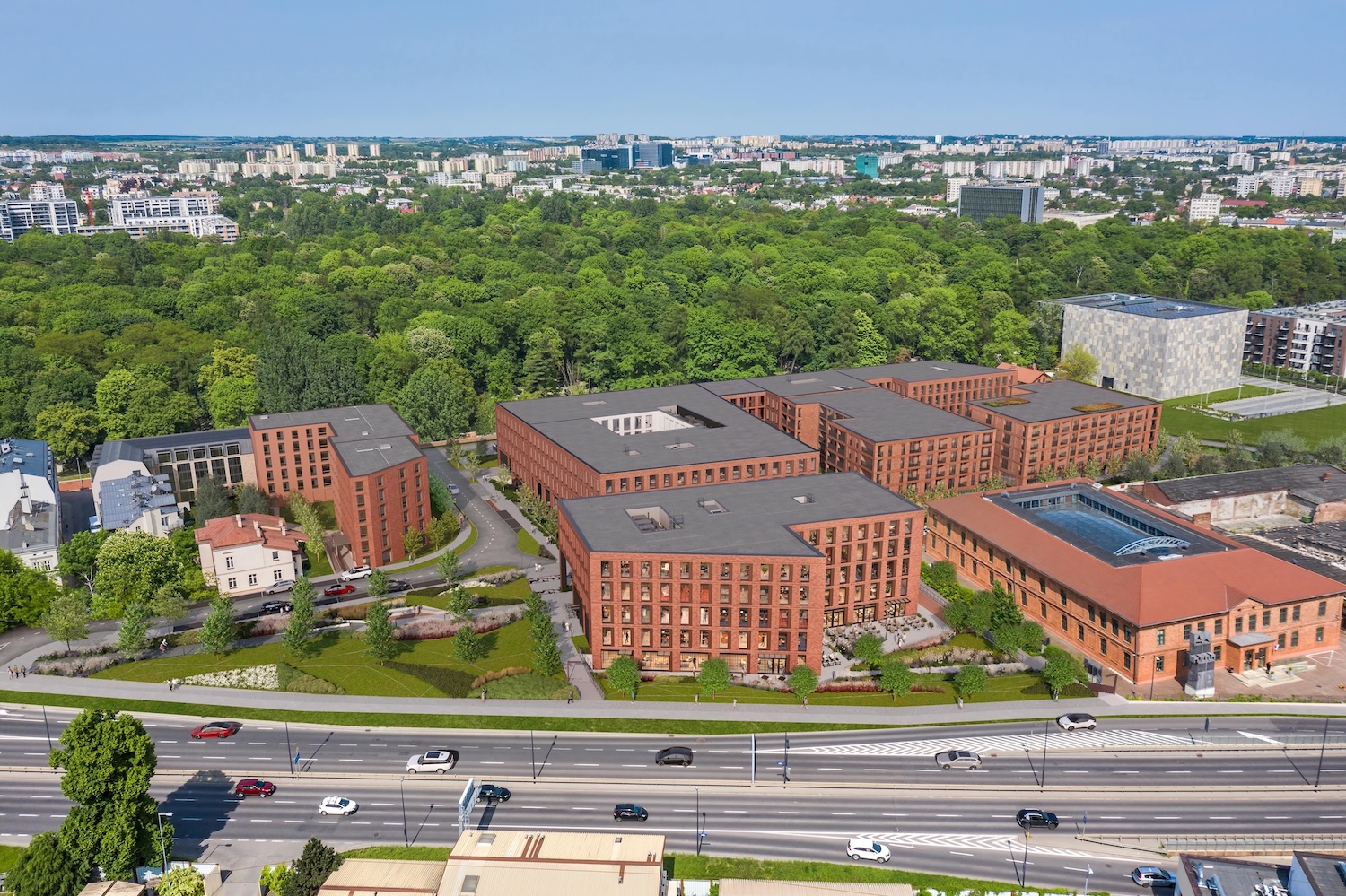 Współczesny kompleks budynków biurowo-usługowych z czerwonej cegły dominuje nad wielopasmową miejską arterią.