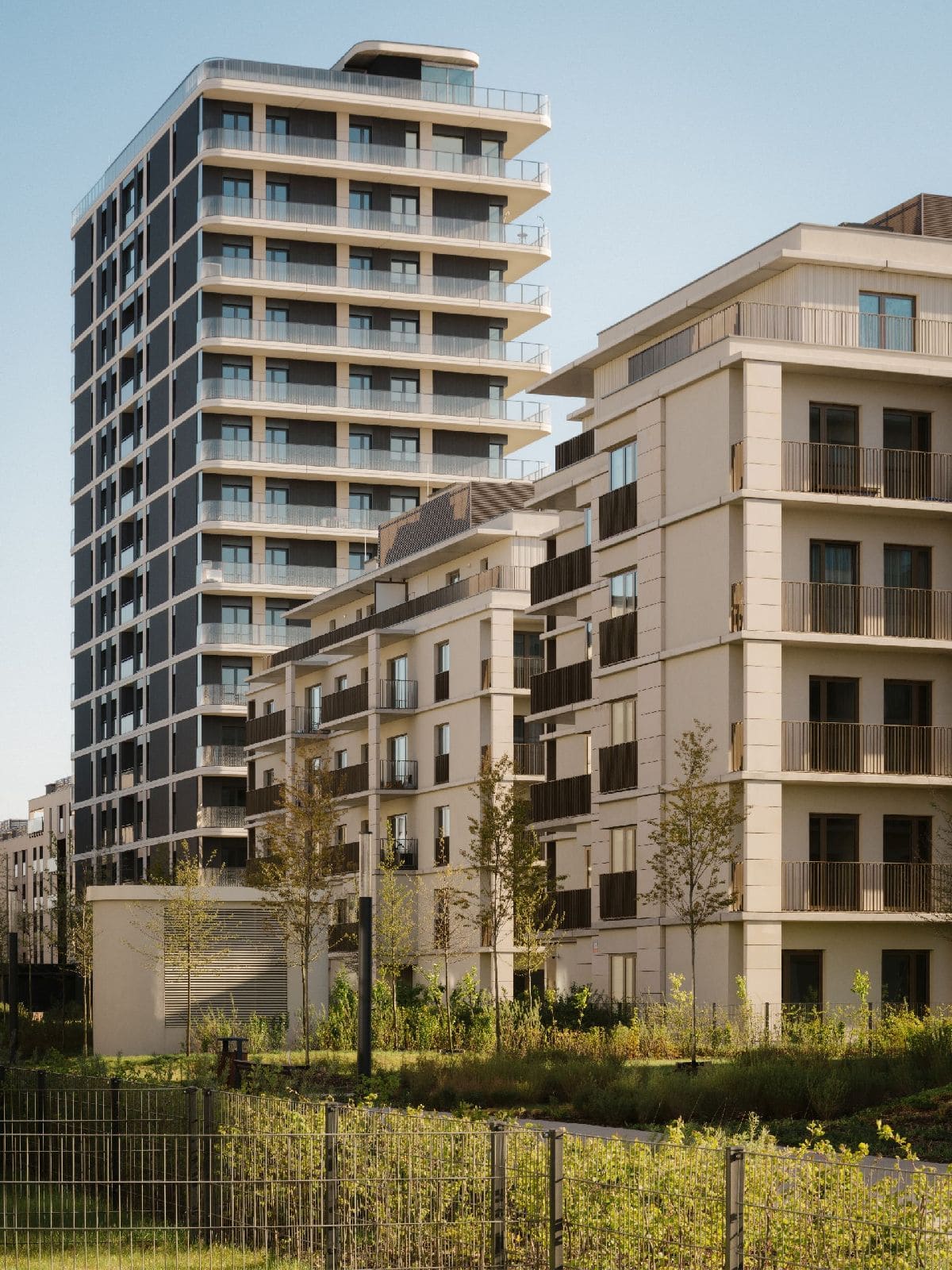Nowoczesny kompleks apartamentowców o zróżnicowanej wysokości w minimalistycznym stylu.