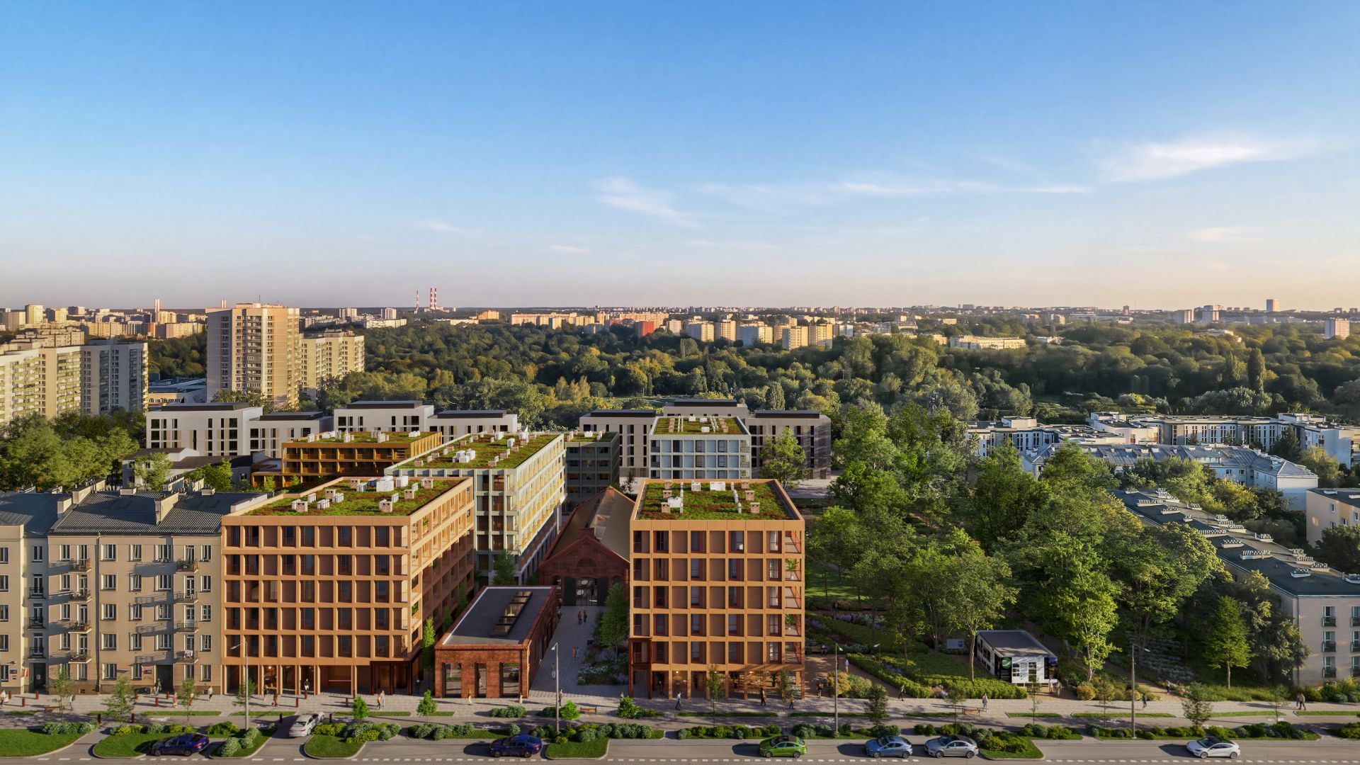 Panorama miasta z lotu ptaka przedstawia kompleks biurowo-mieszkalny z ceglaną i jasną elewacją oraz zielonymi dachami, wkomponowany w zieleń parkową.