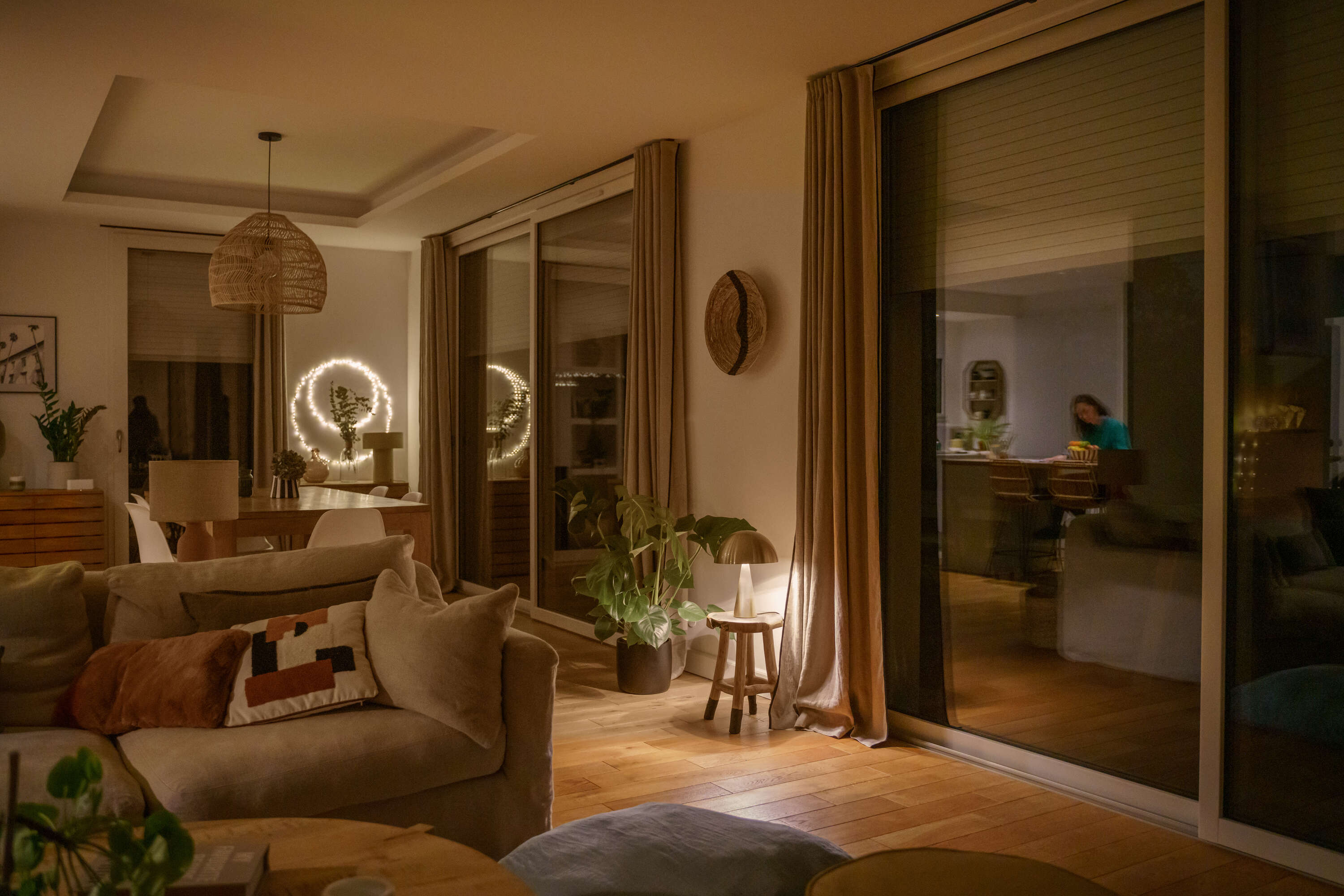 Przytulne wnętrze salonu z jadalnią oświetlone ciepłym światłem lamp wieczorową porą