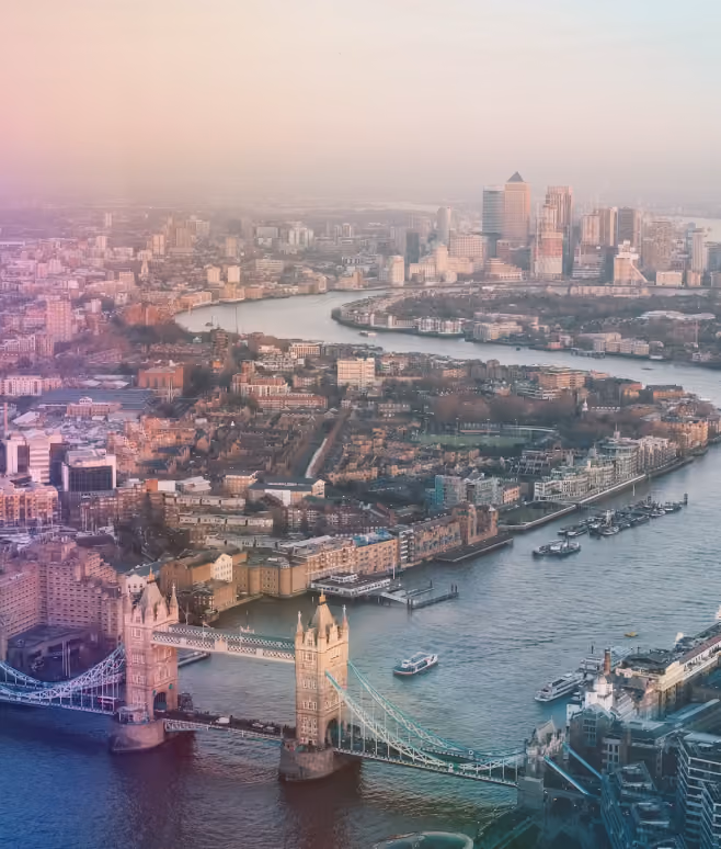 Aerial view of Tower Bridge over the River Thames with London cityscape at sunrise.
