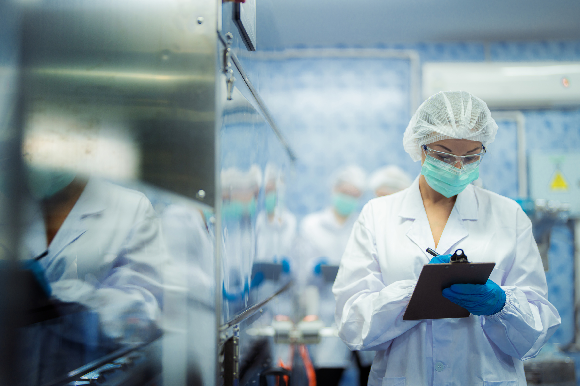 Factory workers checking machine systems on the production line