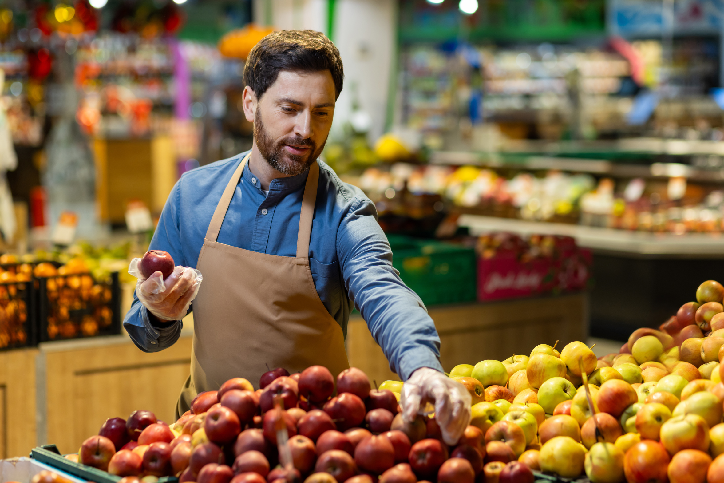 Grocer restocking the fruit display