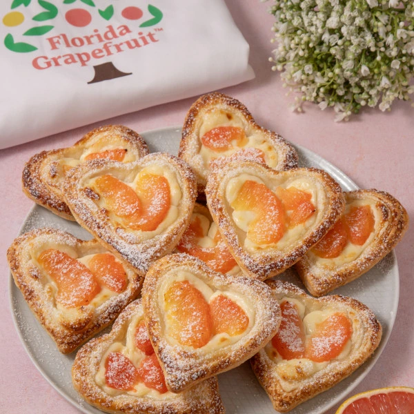 Influencer Marketing Campaign - Plate of heart-shaped pastries topped with powdered sugar and slices of grapefruit, next to a cloth with Florida Grapefruit branding