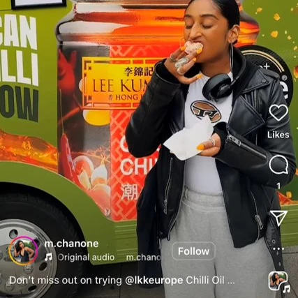 Social Media Influencer with headphones eating food in front of a food truck