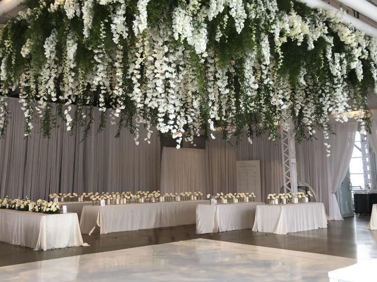 Luxury wedding decor featuring giant hanging floral piece and modern white dance floor at Montreal Science Center