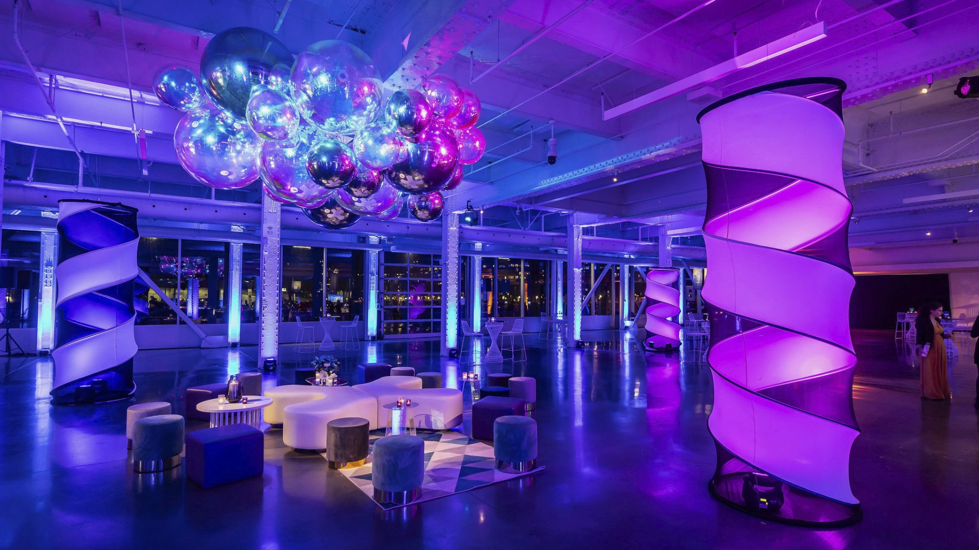 Modern event lounge decor with iridescent and chrome inflatable spheres, LED uplighting, and pinspot lighting at the IRCM fundraiser in Montreal's Grand Quay