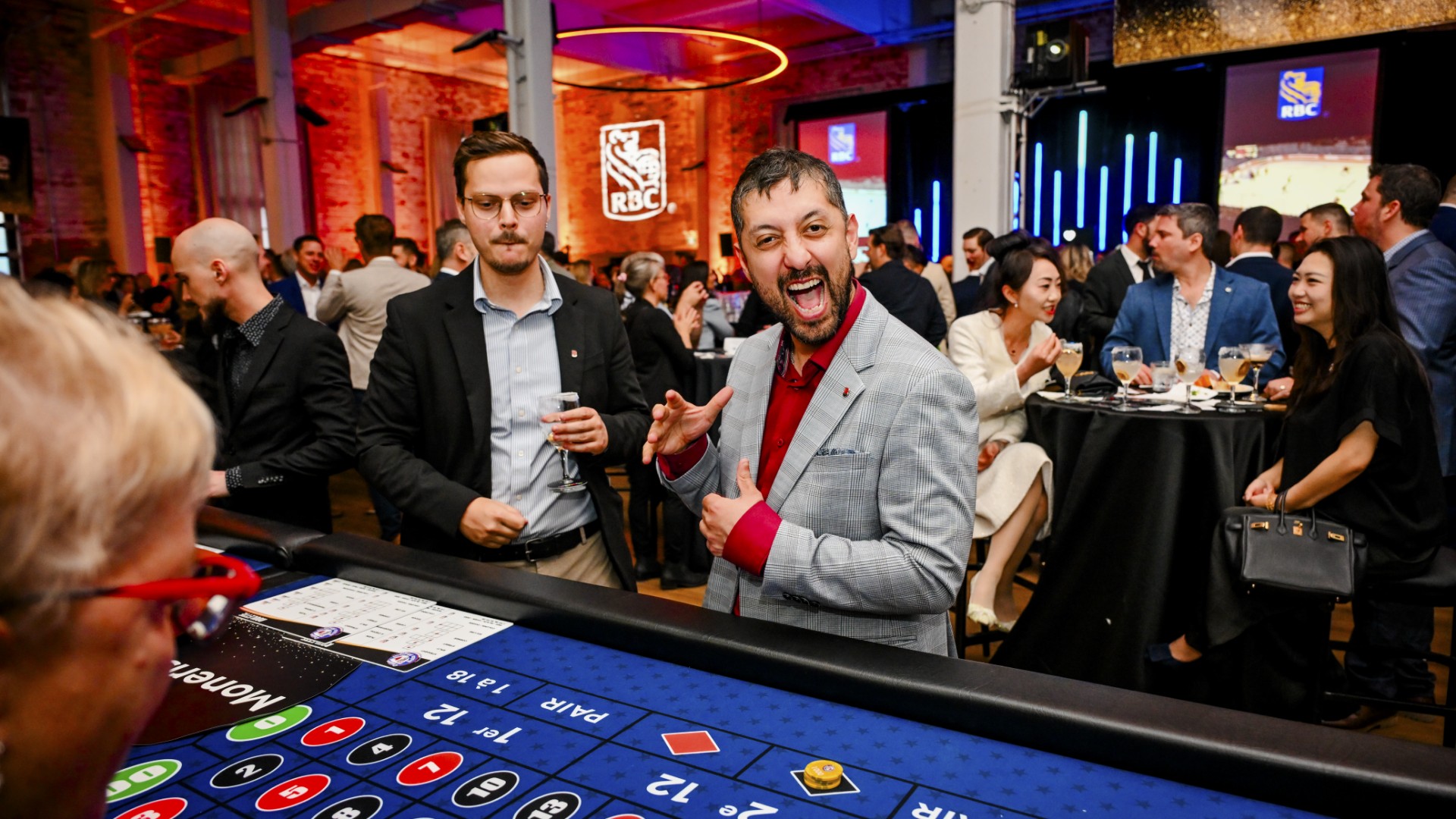 Guests enjoying roulette at RBC Casino Royale fundraiser in Montreal event venue RYE | Gentile, styled with casino decor and elegant tuxedos